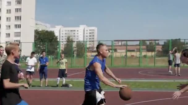 Bobruisk, Belarus - 12 August 2019: Slow motion. Close view. Handsome basketball player catching a ball, throwing it high into the basket — Stock Video