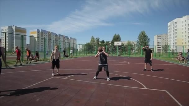 Bobruisk, Fehéroroszország - 2019. augusztus 12.: Lassú mozgás. Közelkép. Dobd egy kosárlabda karika az egyik utcai kosárlabda játékos — Stock videók