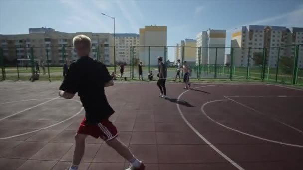 Bobruisk, Bielorrusia - 12 de agosto de 2019: cámara lenta. Jugador de baloncesto callejero driblando y bola de defensa. Lanzar la pelota en la cesta — Vídeo de stock