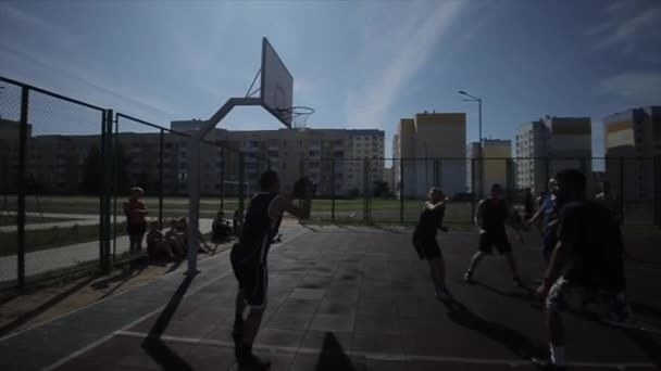 Bobruisk, Bielorrusia - 12 de agosto de 2019: cámara lenta. Jóvenes desconocidos jugando baloncesto en la cancha al aire libre. Haciendo el pase. Poner la pelota en la cesta — Vídeo de stock