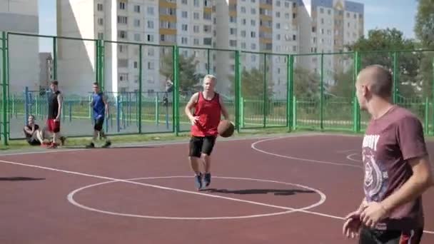 Bobruisk, Bielorrússia - 12 de agosto de 2019: Adolescentes jogadores de basquete de rua defendendo uma bola de seus adversários passando-a um para o outro. Vista aproximada — Vídeo de Stock