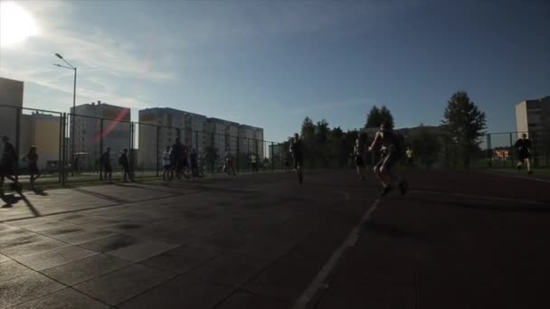 Bobruisk, Bielorrússia - 12 de agosto de 2019: Jovem jogador de basquete fazendo slam dunk durante o jogo de basquete de rua. Movimento lento. Sol brilhante no céu — Vídeo de Stock