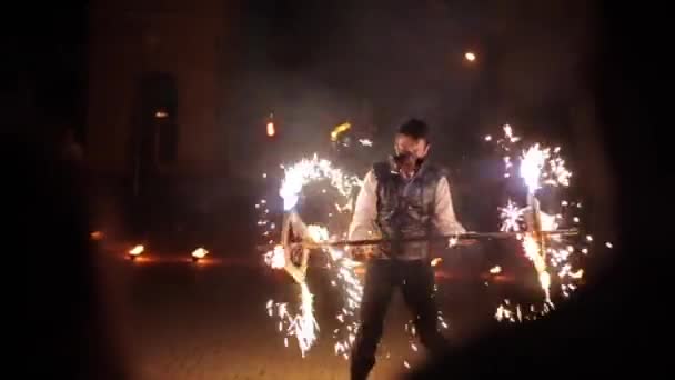 Minsk, Bielorussia - 8 agosto 2019: Il giovane balla da solo con la fiamma durante uno spettacolo di fuoco. Il pubblico lo guarda. — Video Stock
