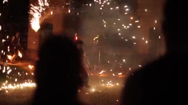 Minsk, Belarus - August 8, 2019: Couple watching fire dance outdoors at night. Close rear view. The image becoming defocused — Stock Video