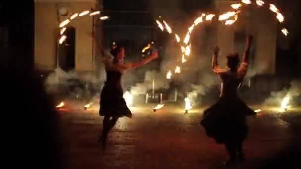 Mińsk, Białoruś - 8 sierpnia 2019: Dwie piękne żonglerki pożarowe tańczące z fanami ognia — Wideo stockowe