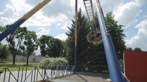 Mogilev, Vitryssland - 25 augusti 2019: Tonåringar njuter av roterande pendelattraktion i nöjesparken. Stäng nedre vy — Stockvideo