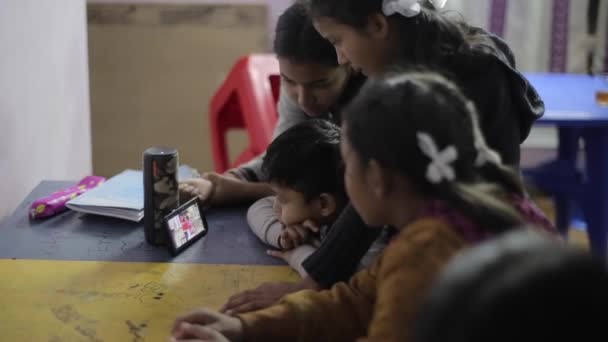 Kathmandu, Nepal - 14 November 2019: Asian Indian nepalese kids watching a video on a smartphone at school in a classroom. — Stock video