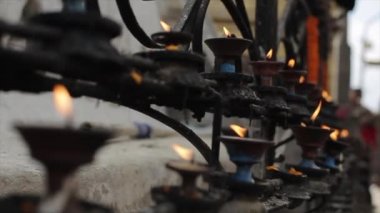 Nepal tapınağında yanan bir ayine yakın çekim. Yanan mumlar, tereyağı lambaları. Katmandu, Nepal.