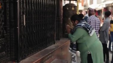 Katmandu, Nepal - 14 Kasım 2019: Nepal 'de bir Nepal tapınağının önünde dua eden nepalli bir kadın.
