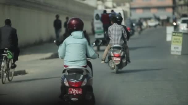 Una vista posteriore di persone nepalesi in sella, guida di scooter e auto sulla strada. Strade di Kathmandu Nepal. Vista auto . — Video Stock