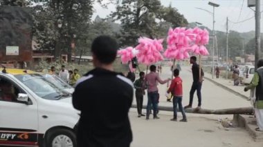 Kathmandu, Nepal - 14 November 2019: Nepalese men selling pink candy floss. Nepal Kathmandu. A car passing by. A rear back view of a local man.