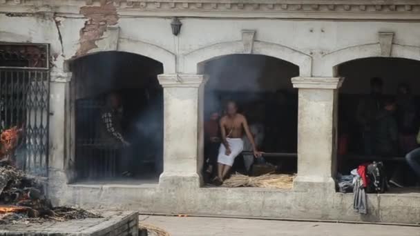 Kathmandu, Nepal - 14 de novembro de 2019: pessoas locais nepalesas sentadas perto de uma cerimônia de cremação em Katmandu, Nepal. Pashupatinath — Vídeo de Stock