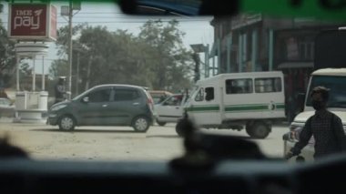 Kathmandu, Nepal - 15 November 2019: Nepalese people crossing busy street, road in Kathmandu, Nepal. View from a car.