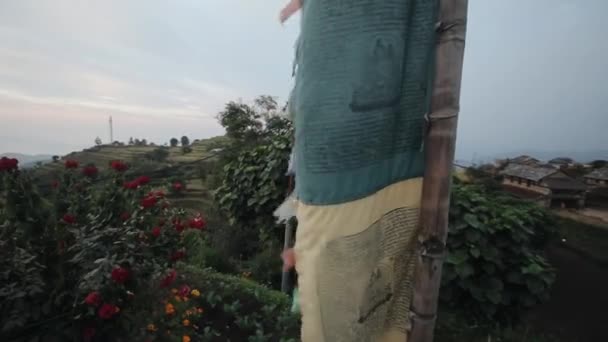 Наближаючись до непальської маленької вітрової локти, моляться прапори, що дмуть вітром. Непал. Прекрасне поле для квітів. Вид з гори, пагорб. — стокове відео