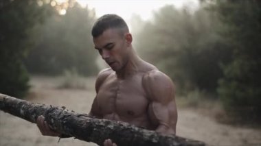 Ormanda egzersiz yapan kaslı yakışıklı adam. Buhar ağızdan gelir. Günaydın.