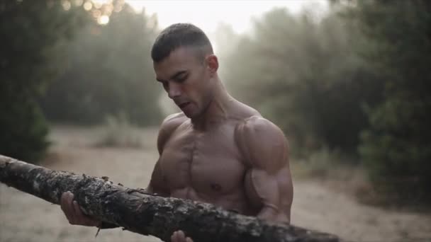 Ormanda egzersiz yapan kaslı yakışıklı adam. Buhar ağızdan gelir. Günaydın. — Stok video