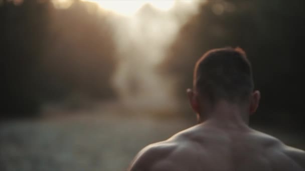 Hombre del deporte corriendo. Ajuste corredor masculino joven muscular con torso desnudo esparciendo árboles de remolacha contra el amanecer, amanecer. Movimiento lento — Vídeos de Stock