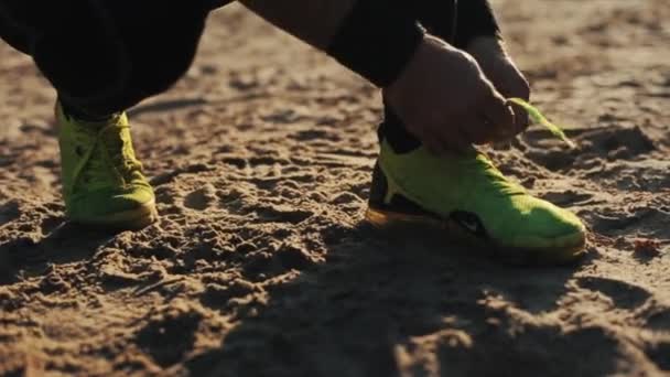 Minsk, Belarus - 11 November 2019: Close up of Tying the running shoes on the sand. — Stock Video