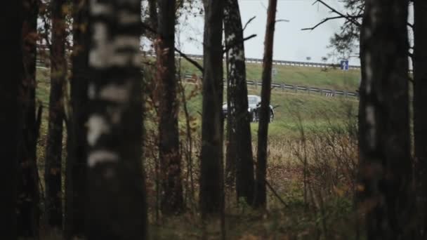 Минск, Беларусь - 11 ноября 2019 года: автомобиль быстро едет на фоне леса . — стоковое видео