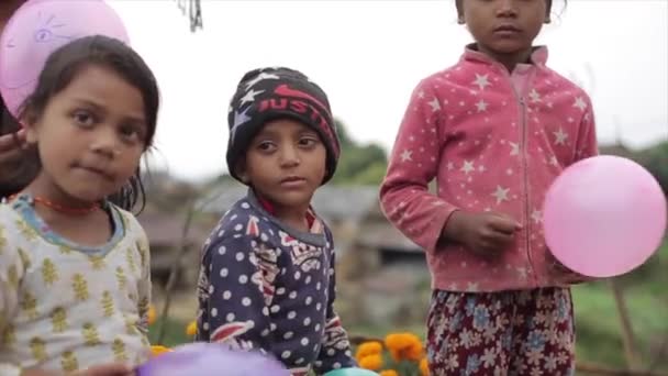 Katmandu, Nepal - 19 Kasım 2019: balon tutan sevimli nepalli çocukların yakın çekimi. Nepal, köy. Kameraya bakıyorum.. — Stok video