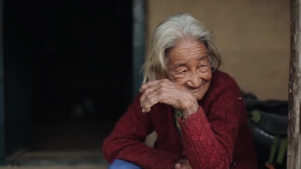 Kathmandu, Nepál - 19. listopadu 2019: Zblízka na starou nepalskou ženu, babička sedí venku na verandě. — Stock video