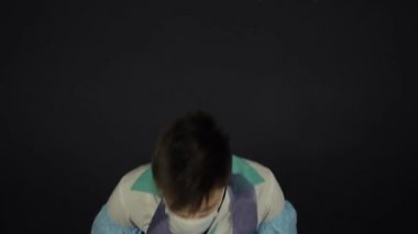 Kafkasyalı genç bir doktor nefes almakta zorlanıyor, öksürüyor. Koruyucu giysiler, takım elbise, maske ve eldiven giyiyor. İzole edilmiş siyah arka plan. Coronavirus, Covid19.