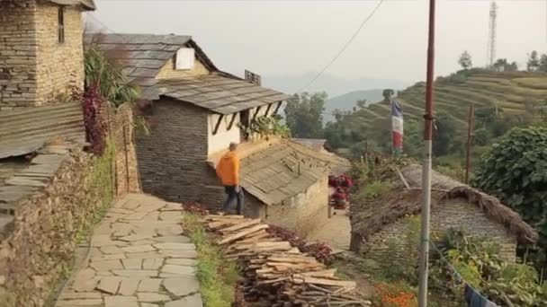 Un homme caucasien marchant dans les rues népalaises d'un village. Vue des rizières en terrasses . — Video