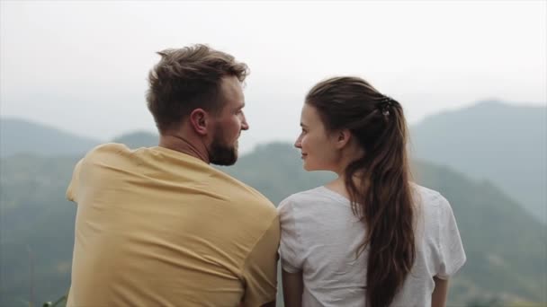 Una linda pareja caucásica joven abrazándose en la cima de una montaña. Vista trasera cerrada. Nepal. Paisaje . — Vídeo de stock