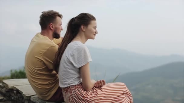 Ένα χαριτωμένο νεαρό καυκάσιο ζευγάρι αγκαλιάζεται, αγκαλιάζεται στην κορυφή ενός βουνού. Με κοντινή θέα. Νεπάλ. Τοπίο. Γαμήλιο ταξίδι. — Αρχείο Βίντεο