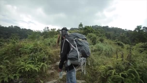Katmandu, Nepal - 14 november 2019: Baksidan av en grupp manliga turister som vandrar med ryggsäckar och vandrar till gröna kullar i Nepal. Natur, skog, grönt. — Stockvideo