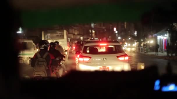 ネパールのカトマンズ- 14 11月2019:ネパールの忙しい道路で夜に渋滞に巻き込まれた車からの眺め。夜だ。アジアの通り。ネパール・カトマンズ. — ストック動画