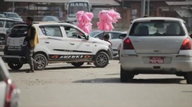 Katmandu, Nepal - 19 Kasım 2019: Nepalli adamlar Katmandu, Nepal 'de bir yolun ortasında pembe pamuk şeker satıyorlar. Trafik, araçlar, yürüyen insanlar..