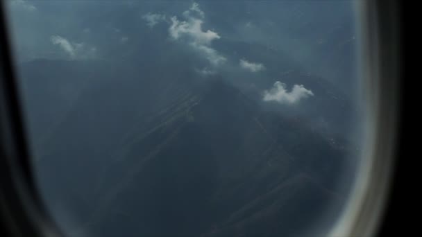 Widok z okna samolotu na góry Himalaje pokryte chmurami. Nad górami Alp. — Wideo stockowe