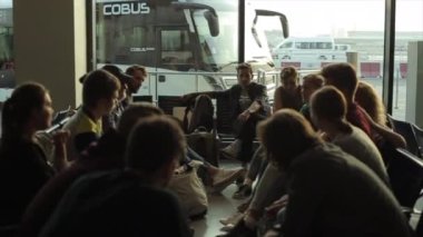 Dubai, BAE - 19 Kasım 2019: Terminalin bekleme salonunda bekleyen bir grup insan. Konuşmak, bir çember içinde oturmak, gönüllüler..