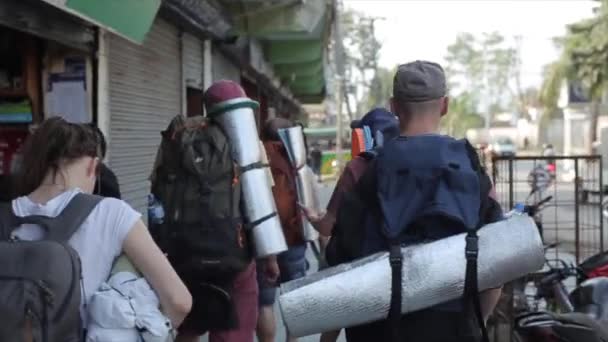 Katmandú, Nepal - 14 de noviembre de 2019: Vista trasera de un grupo de viajeros con mochilas caminando por un pueblo nepalés. Nepal, ciudad, Katmandú . — Vídeos de Stock