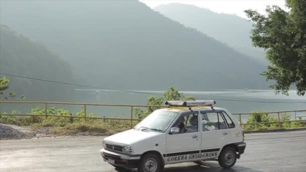 Kathmandu, Nepal - 14 novembre 2019: Veicoli, autobus, auto che passano in Nepal. Montagne, lago sullo sfondo. Traffico asiatico . — Video Stock