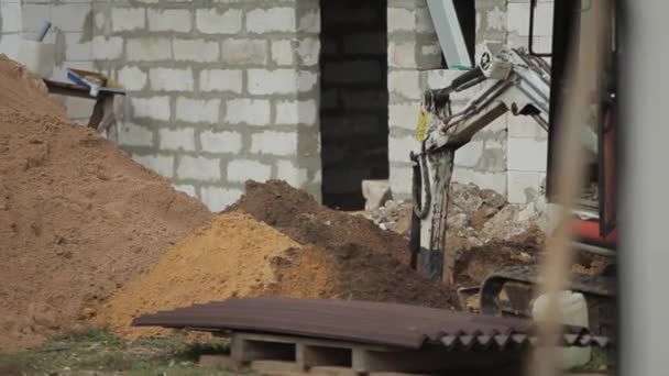 Bobruisk, Fehéroroszország - 2019. október 14.: Hidraulikus vödör hernyó mini kotró munka közben. Közelkép — Stock videók