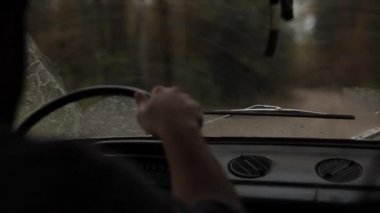 Silecekleri çalışan arabanın ön camındaki manzara.