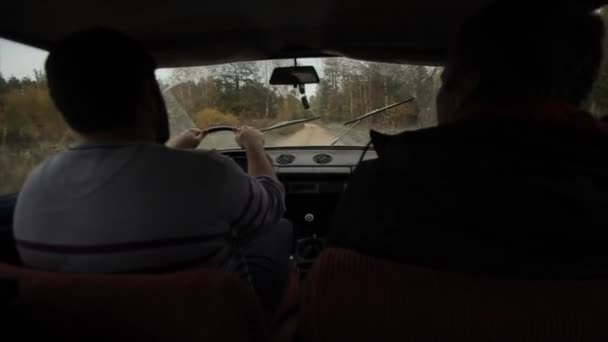 Bobruisk, Belarus - 14 October 2019: Men in a car driving on a road in the forest. Back view. Slow motion — Stock Video
