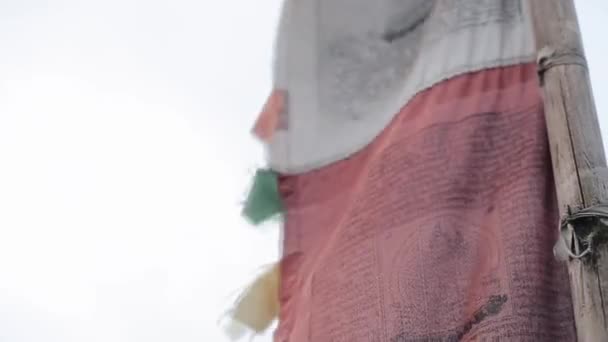 Een close-up van nepalese kleine wind lokta gebed vlaggen waait in de wind. Nepal. Prachtig bloemenveld. Uitzicht vanaf een berg, heuvel. — Stockvideo