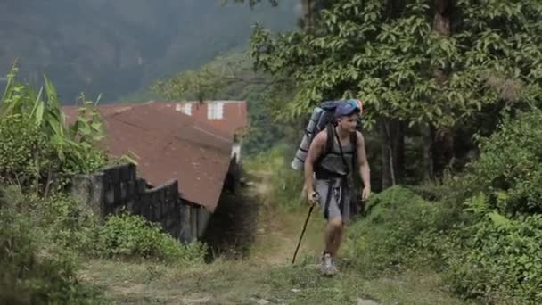 Un turista caucásico con una mochila caminando, caminando por la estrecha calle de piedra nepalesa. Nepal, pueblo . — Vídeos de Stock