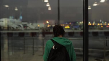 Genç bir kız, bir kadın gece havaalanında bekleyen ve fotoğraf çeken bir kadın. Arka arkaplan.