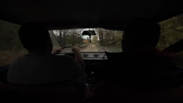 Бобруйск, Білорусь - 14 жовтня 2019: Чоловіки в автомобілі їдуть по дорозі в лісі. Назад. Повільний рух — стокове відео