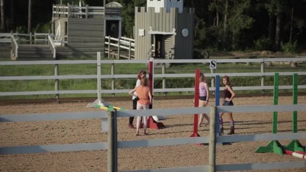Minsk, Vitryssland - 19 juli 2019: Unga flickor förbereder platsen för ridtävlingar — Stockvideo