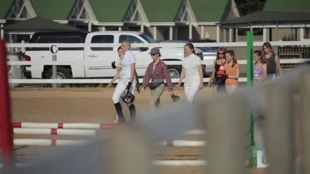 Minsk, Biélorussie - 19 juillet 2019 : Des jeunes femmes jockeys et leurs assistantes inspectent un site de compétition équestre — Video