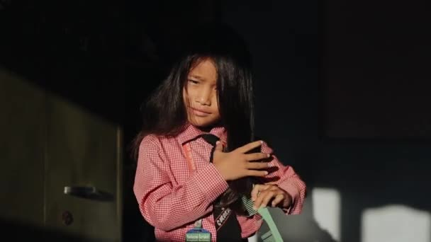 Katmandú, Nepal - 14 de noviembre de 2019: Una niña nepalesa peinándose, trenzándose, peinándose el pelo antes de ir a la escuela. Uniforme escolar. Día soleado. Sonriendo a la cámara . — Vídeos de Stock
