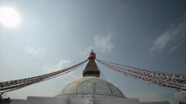 Beyaz bir Nepal tapınağı, stupa. İnsanlar tapınağa doğru merdivenlerden çıkıyorlar. Parlak gökyüzü. Güneşli bir gün. Nepal Katmandu.