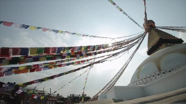 Beyaz bir Nepal tapınağı, stupa. İnsanlar tapınağa doğru merdivenlerden çıkıyorlar. Parlak gökyüzü. Güneşli bir gün. Nepal Katmandu. — Stok video