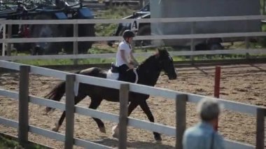 Minsk, Belarus - 19 Temmuz 2019: Binicilik yarışmalarında bir jokey kızla dörtnala giden bir atın seyirci tribününden görüntü