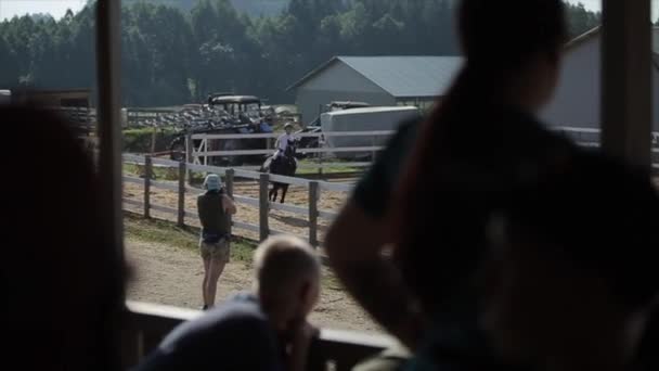 Minsk, Bielorussia - 19 luglio 2019: saltare le barriere nelle competizioni equestri. Vista dal rostro da dietro le persone — Video Stock